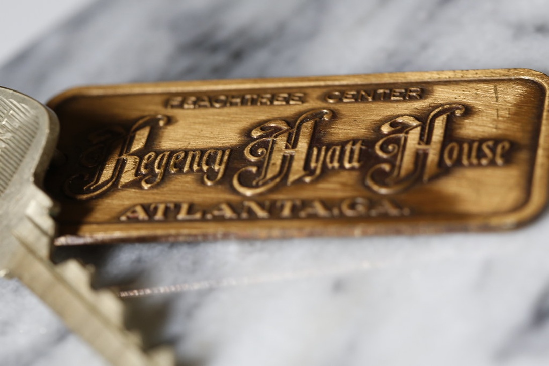 Nahaufnahme eines traditionellen Hotelzimmerschlüssels aus Metall mit Messinganhänger, der die Aufschrift 'Teachers Center Regency Hyatt House Atlanta GA' trägt. Er symbolisiert die physischen Schlüssel, die durch digitale Hotelschlüssel abgelöst werden.